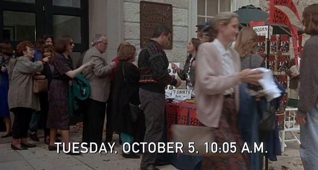 A crowd outside a courtroom lines up to buy "Serial Mom" merchandise like pennants and tshirts. The scene is labeled "Tuesday, October 5, 10:05 A.M."