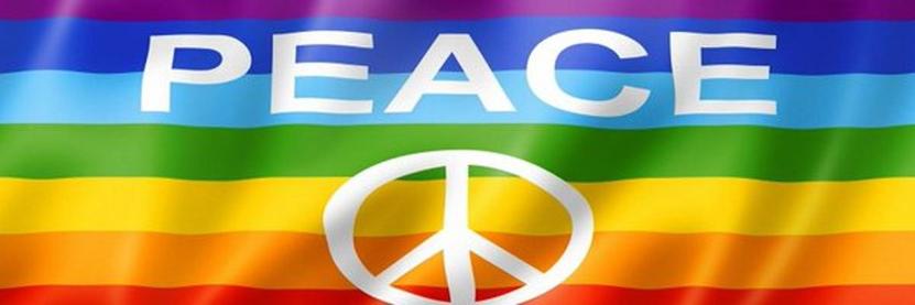 Bandiera arcobaleno sventolante con la scritta bianca "PEACE" in maiuscolo e un simbolo della pace bianco centrato nella parte inferiore.