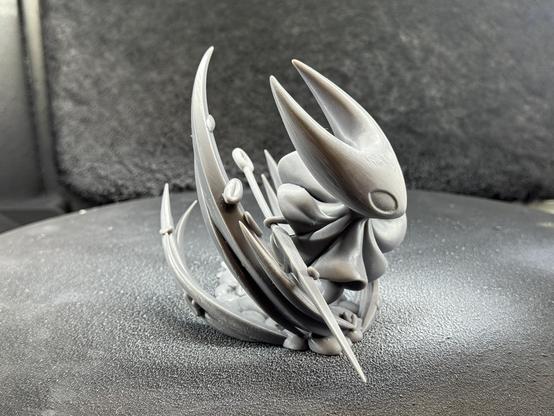 A 3d printed model of Hornet from Hollow Knight Silksong. It’s in the raw grey resin before priming. Shown from the left side.