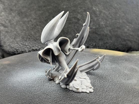 A 3d printed model of Hornet from Hollow Knight Silksong. It’s in the raw grey resin before priming. Shown from the back.