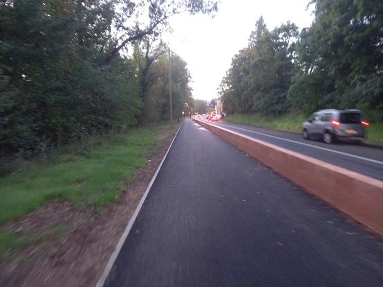 Une piste cyclable lisse comme un billard, séparée de la route par une bordure en béton.