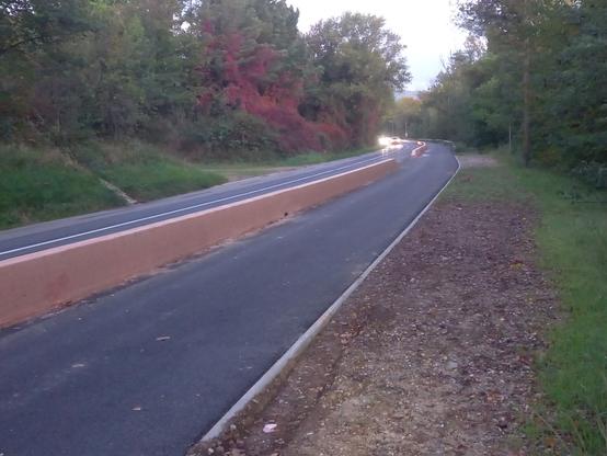 Une piste cyclable lisse comme un billard, séparée de la route par une bordure en béton.