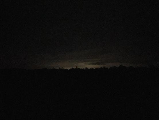 A thin band of light at horizon in an otherwise cloudy and dark night. Imagine the cricket chirr as backdrop