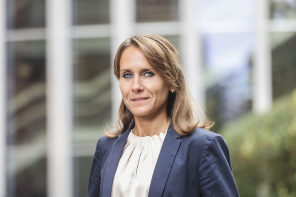 Porträtfoto von Nadine Anskeit, PHKA-Prorektorin für Forschung. Nadine Anskeit lächelt leicht, blickt Betrachter:innen direkt an (Brustbild nach halblinks, Kopf in Vorderansicht), im Hintergrund Glasfassade der PHKA. Nadine Anskeit hat halblange, offene Haare, trägt Blazer und Bluse. Foto: PHKA/Andrea Fabry