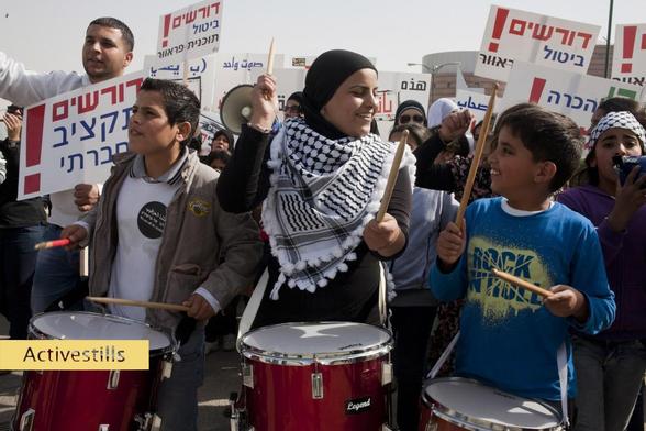 Protest von Frauen gegen die Vertreibung der Beduinen, Beʾer Scheva, Israel, 21.3.2012
Fotograf: Keren Manor / Activestills

Das Foto zeigt eine Frau die einem Jungen anlächelt, beide spielen während des Protestes auf Trommeln.