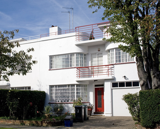 A colour photograph of a house in Lytton Close with white rendered walls, curved windows and metalwork balconies