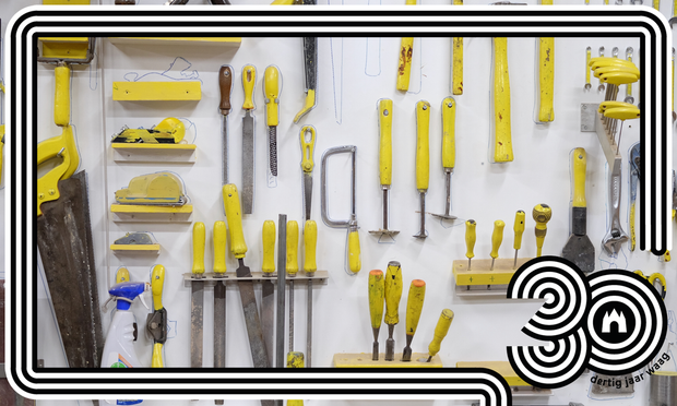 Foto van een witte wand met gereedschappen die aan de muur opgehangen zijn zoals een zaag, verschillende beitels, schaven, plamuurmessen, en handzagen. Alle gereedschappen hebben een geel handvat. Om de foto heen is een grafisch frame te zien met zwart witte lijnen die retro aanvoelen en de cijfers '30' staan rechts onderin met het logo van Waag, en de tekst dertig jaar Waag eromheen.