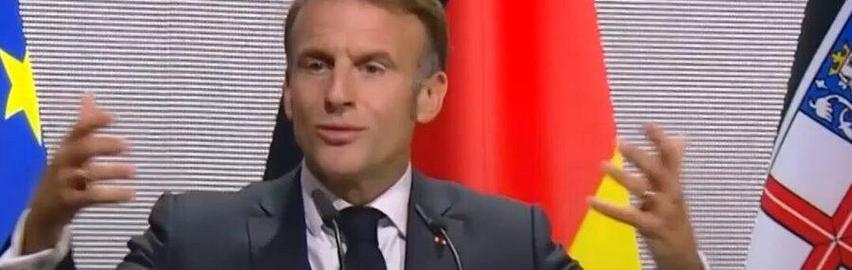 Der französische Präsident Macron bei einer Rede. Ausschnitt nah Oberkörper. Beide Hände/Arme gestikulierend von sich gestreckt.