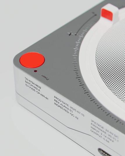Close-up of a modern device featuring a sleek grey and white design, power button, volume control, and production details.