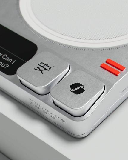 Close-up of a modern device featuring buttons with symbols and text, including kanji and a Microsoft Copilot logo on a sleek, metallic surface.