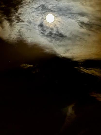 Almost white moon behind clouds; an evening in North London