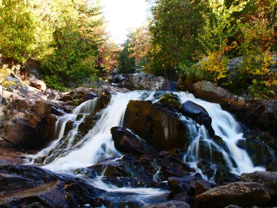 A waterfall with a slight long-exposure effect. The trees on each side are showing early fall colours. 

f22, 1/2s, iso200, 25mm (14-150mm)