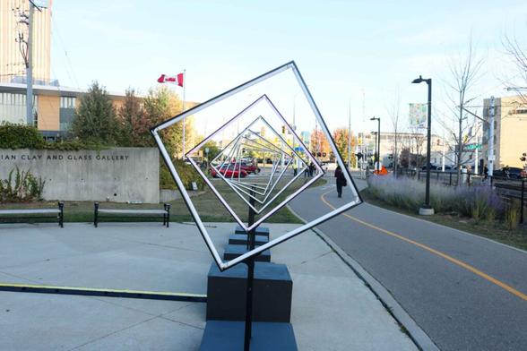 Photo of an installation of empty square frames, mounted in such a way that they appear to be spinning in delayed sequence despite being static, in Waterloo, Ontario.
