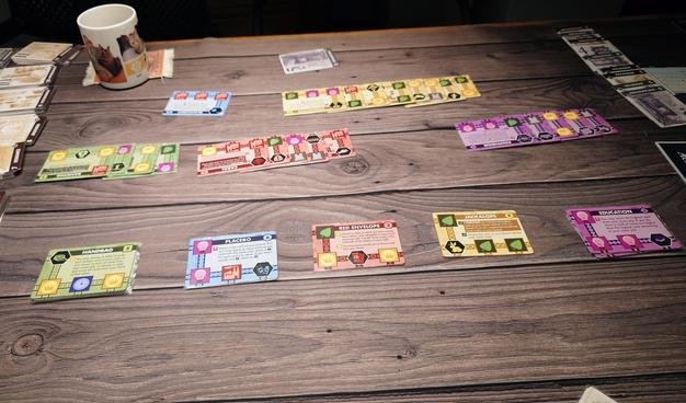 A table with ten piles of cards in 5 colours. Some of them are splayed.