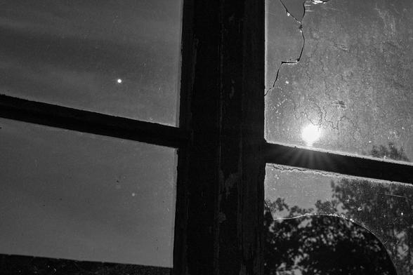 B&W-Foto von einem Fenster von innen. Nachtaufnahme mit einem Vollmond.