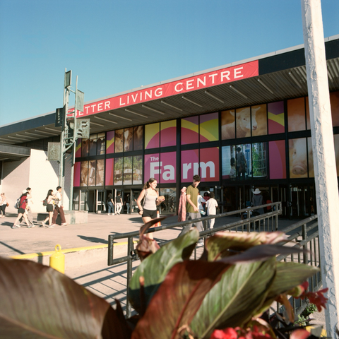 People gather and enter the Better Living Centre and banners advertise an exhibit entitled “The Farm”.