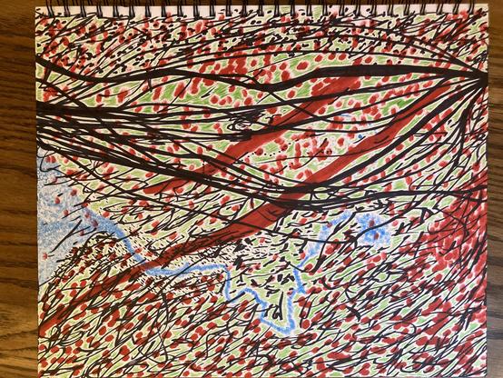 wonky abstract drawing.
on paper, within a wire-bound art pad.
white, black, green, blue, red.
lying on a wooden surface.