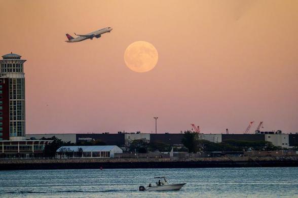 Dual sunset/moonrise over Logan Airport, by Adam Balsam