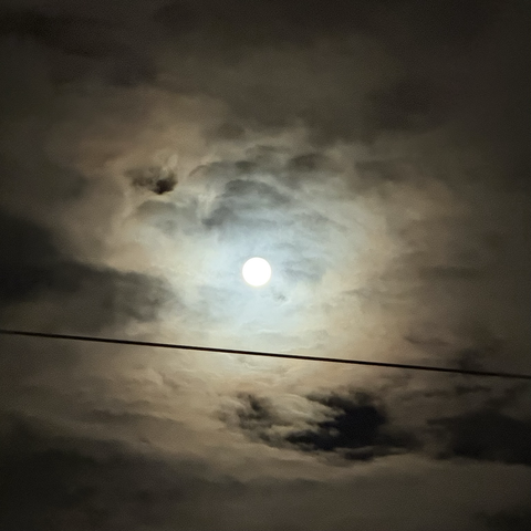Blick durch die Wolken auf den Vollmond.