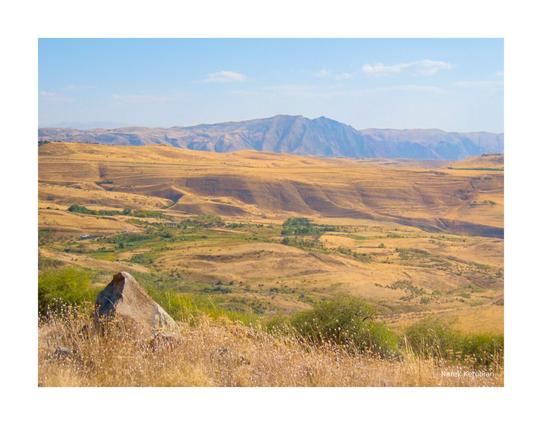 An Armenian autumn landscape with dried up grass, rolling hills and mountains
