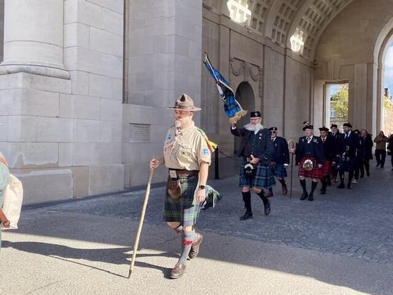 On my way back to the Grote Markt of Ypres, after laying the wreath at the Menin Gate. 
Man in scout uniform and MacLaren kilt, followed by other men in kilts, under the Menin gate.