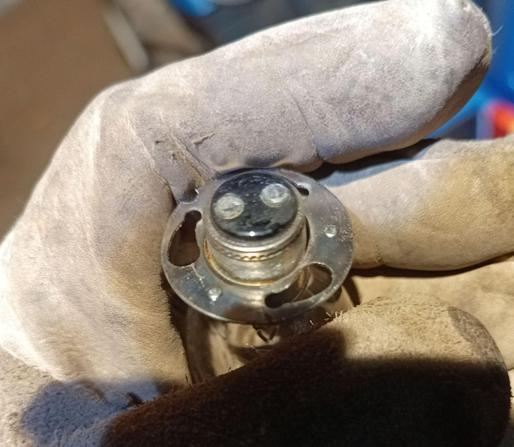 Bottom of a APF type lightbulb with two electric contacts (plus mass on the case) and a three-hole twist-lock fitting.