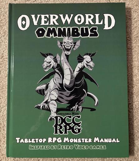 The cover of the Overworld Omnibus for DCC RPG, showing a three-headed hydra on a green background. The text at the bottom reads “Tabletop RPG Monster Manual Inspired by Retro Video Games.”