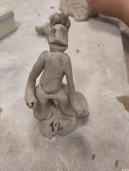 Eine plastizierte Figurine, stehend aus frischem Ton gearbeitet.