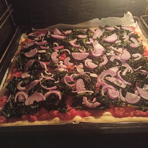 Pizzateig mit Tomaten, Cavolo Nero und Zwiebeln im Backofen...