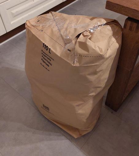 Lähes pöydän korkuinen ruskea pahvipussi pullollaan villaa