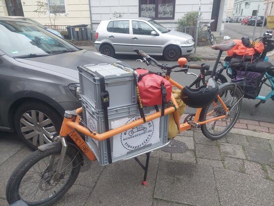 Ende der Schokofahrt: ein voll beladenes Lastenrad steht zum abladen am lokalen Bioladen.
