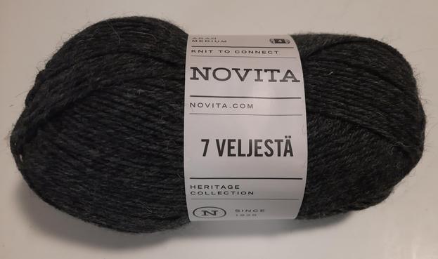 Neues Wollknäuel der Firma Novita, Farbe dunkelgrau. Auf der weißen Banderolle steht gut sichtbar "7 VELJESTÄ".