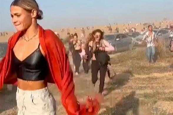 One of the infamously iconic images of 7 October, 2023 - audience fleeing from the Nova Music Festival, in the foreground a beautiful woman with a black top, a red scarf and a desperate face. She is running. And crying.