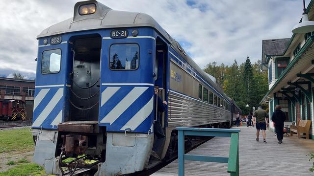 a rail diesel car train number BC-21. blue and white striped at the front, stainless steel bottom on the side.
