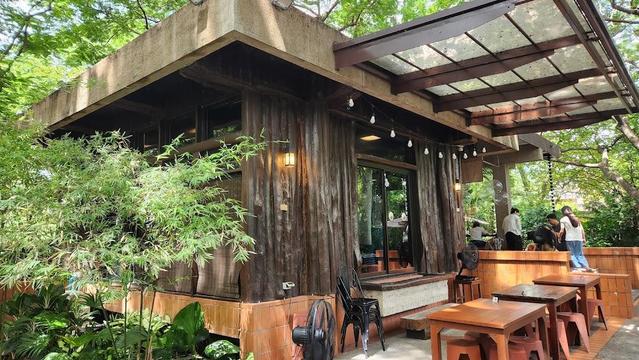 An outdoor cafe with wooden tables and chairs.