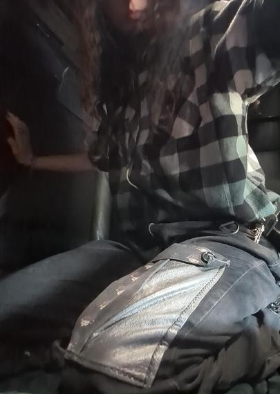 man kneeling in bed wearing black jeans with large pleather + organic cotton printed canvas & black/grey/white flannel top