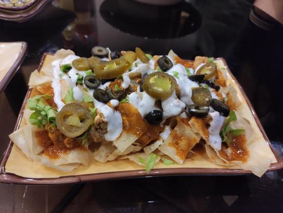 A plate of loaded nachos with toppings.