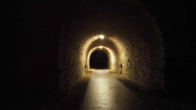 Beleuchteter Tunnel in schwarzer Umgebung