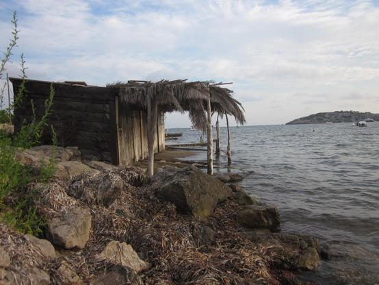 Eine Fischerhütte direkt am Strand von Ibiza - idyllisch gelegen auf Felsen direkt am Meer. Wenn der Meeresspiegel durch die Erderwärmung steigt, ist die Hütte bedroht.