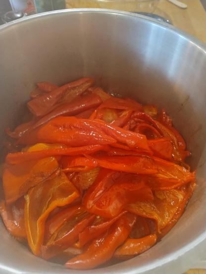 Roasted red peppers in a stainless steel pan