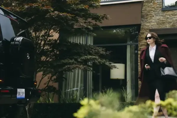 A woman walks towards a car in Bugonia
