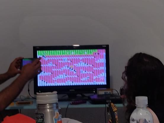 Asistente al taller Son of a Glitch provocando catridge glitches a un cartucho de videojuegos.