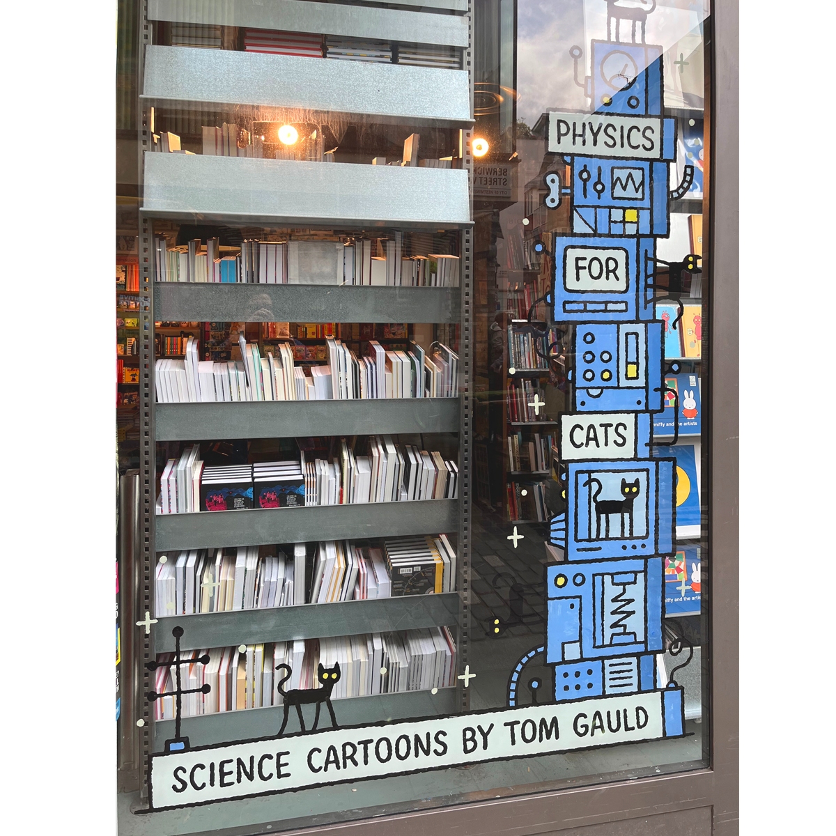Cartoon cats and science machinery painted on a window.