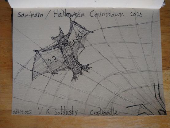 Doodle of a bat caught in a spider's web. The web covers most of the page & the bat is in the top two thirds on the right of the picture. Wings spread as though caught mid flap. The threads crisscross over the bat. On the underside of it's wings we see written: 23 Days!
The centre of the web seems to be beyond the edge of the paper but cloto the bottom left corner as the spoke threads get close to converging here. Also we see the four front legs of the spider & the mandibles just peaking in at this corner. 
Across the top of the image are the words: Samhain / Halloween Countdown 2025
Along the bottom of the image it reads: 08102025 — V K Soldusty — CrapDoodle