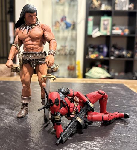 The same picture but now Conan is glaring at Deadpool.