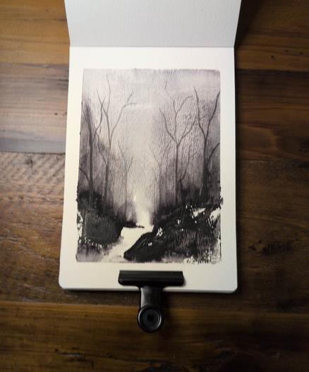 This is an Atmospheric Watercolor Landscape Painting in portrait orientation in an A5 sketchbook using Daniel Smith Lunar Violet and Shadow Violet.  This piece is  quite dark on the bottom half with a few areas of water white watercolor paper showing through. A lot of pigment is pushed into the atmosphere  making for an eerie feel.  The are a few ghostly thin leafless trees reaching nearly to the top of this artwork.