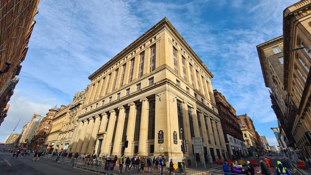 A Glasgow street lined with traditional sanstone buildings.