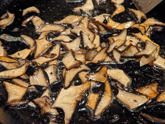 Thin slices of the caps are browning and sizzling away in a cast-iron skillet.
