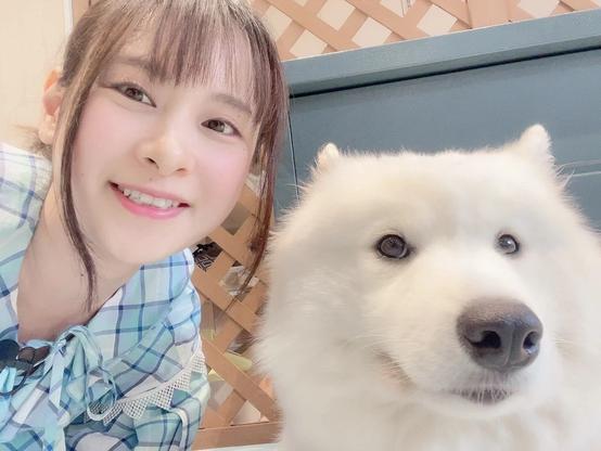 A selfie of a woman smiling with a dog.