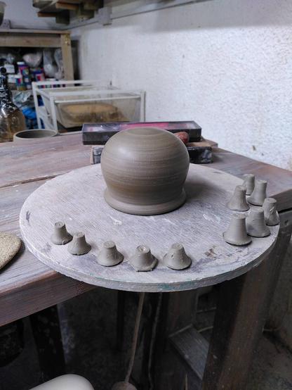 Trimmed upside down clay cauldron and a selection of thrown feet.